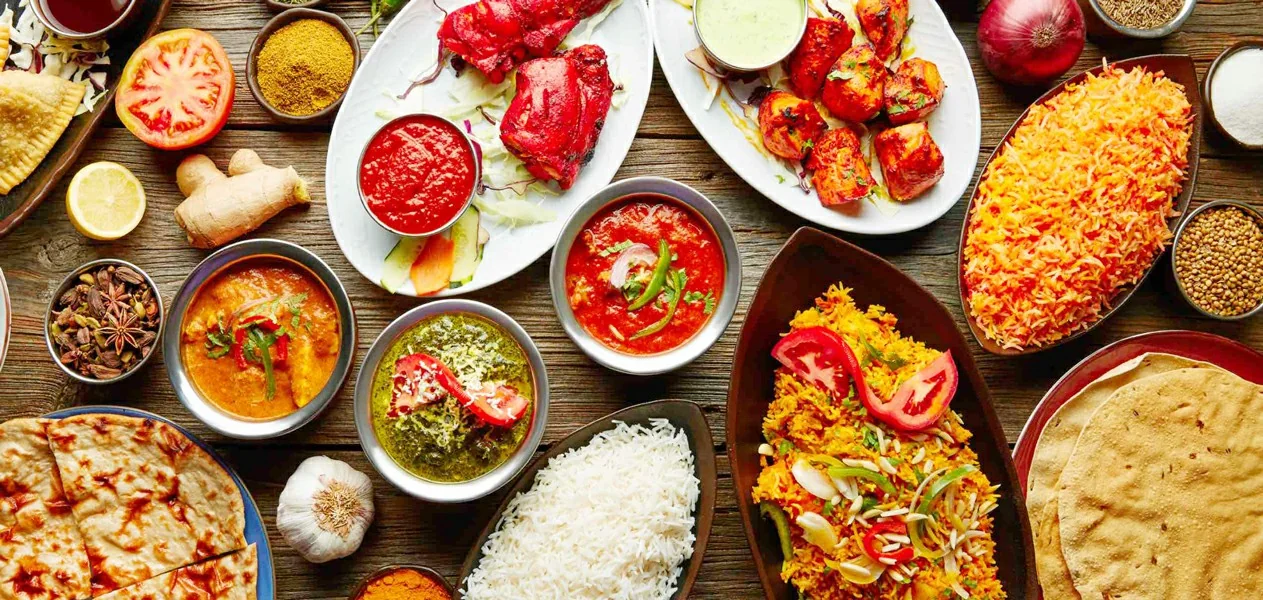 Bogata izloženost egipatskih i orijentalnih jela s rižom, curryjem, mesom i začinima na drvenom stolu
